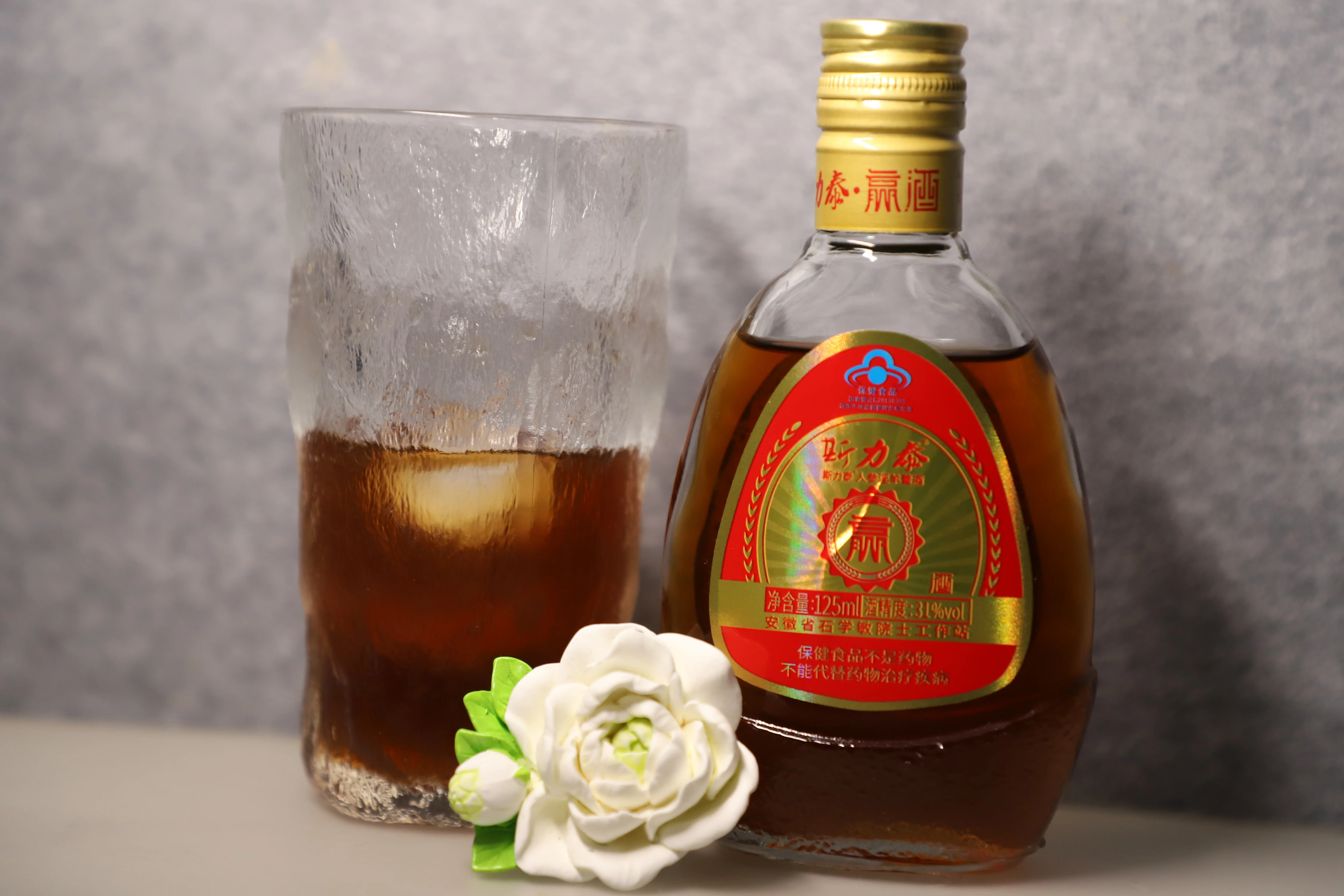 一个装有深琥珀色坐骨神经痛药酒的玻璃罐，内部清晰可见威灵仙、川芎等中药材，旁边散落着药材和手写配方。_1