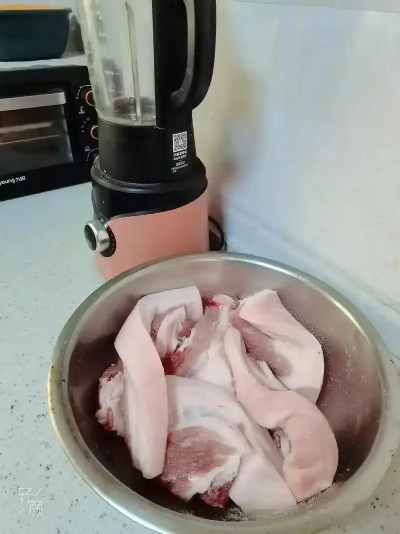 切好的腊肉片与一瓶打开的白酒特写，展示传统腌腊美食的制作场景_1