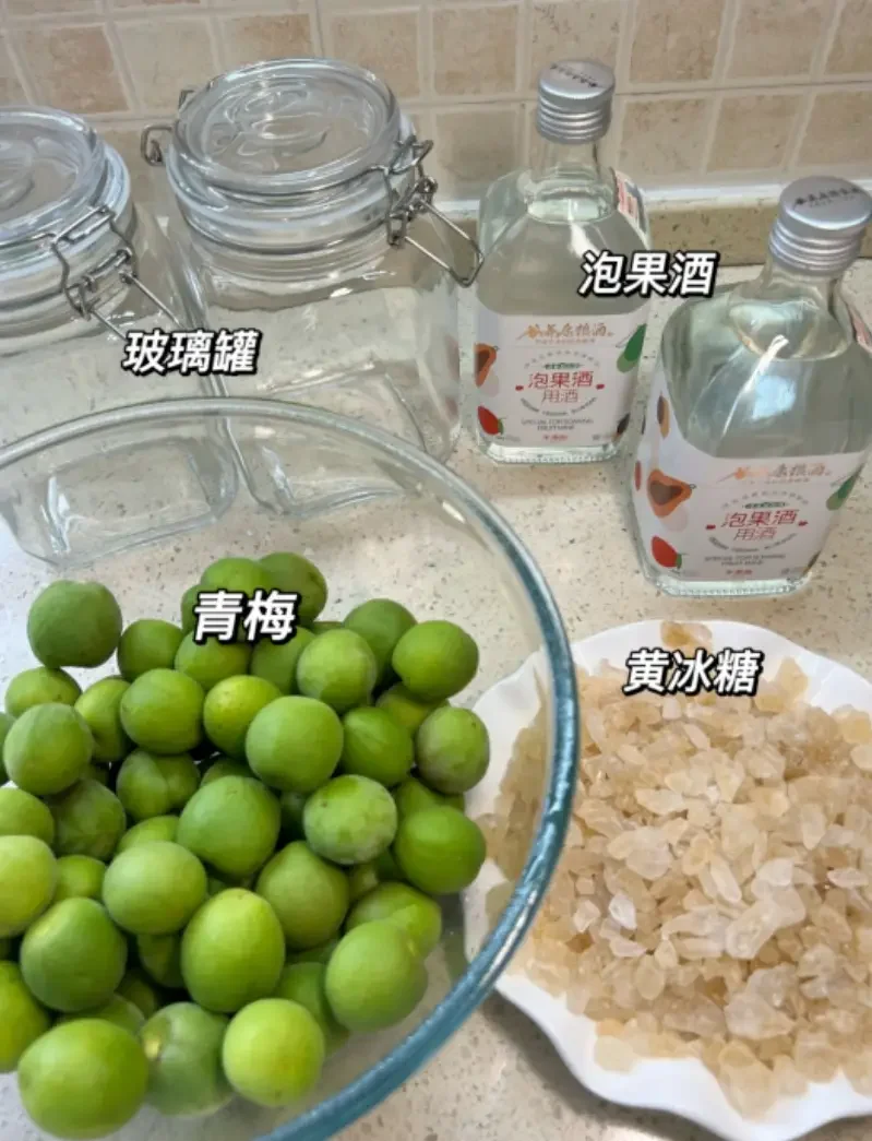 一瓶金黄色的自制青梅酒与新鲜青梅、冰糖、竹耙在木桌上的温馨组合，展示家庭酿酒的乐趣。_1