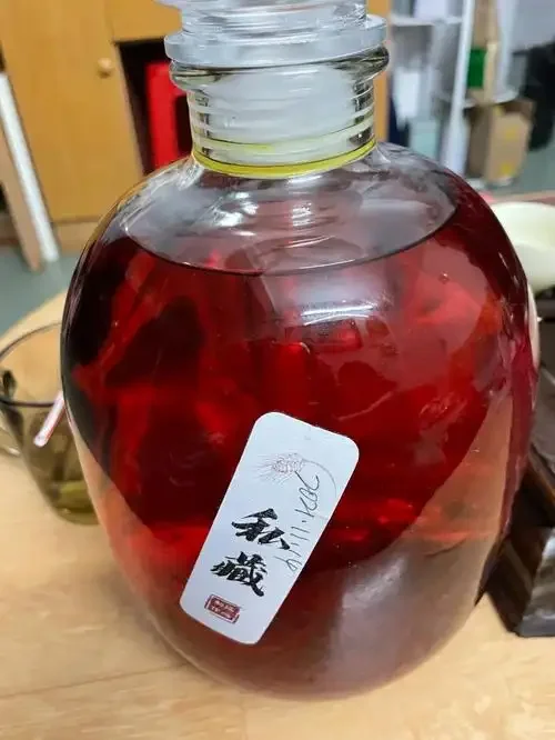 玻璃瓶中金黄色的藏红花泡酒特写，酒液清澈，藏红花丝清晰可见。_1