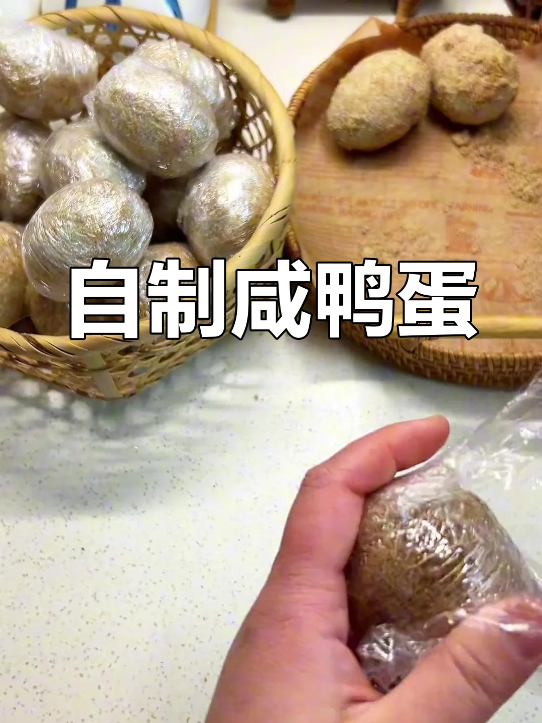 手工腌制咸鸭蛋过程特写:双手正在用保鲜膜包裹一颗裹满粗盐的鸭蛋_1