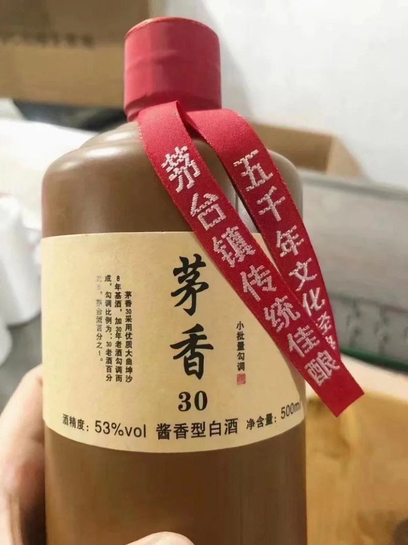 专业品鉴2003年茅台镇酱香老酒场景：白瓷杯中的微黄酒液与背景的老酒瓶_1