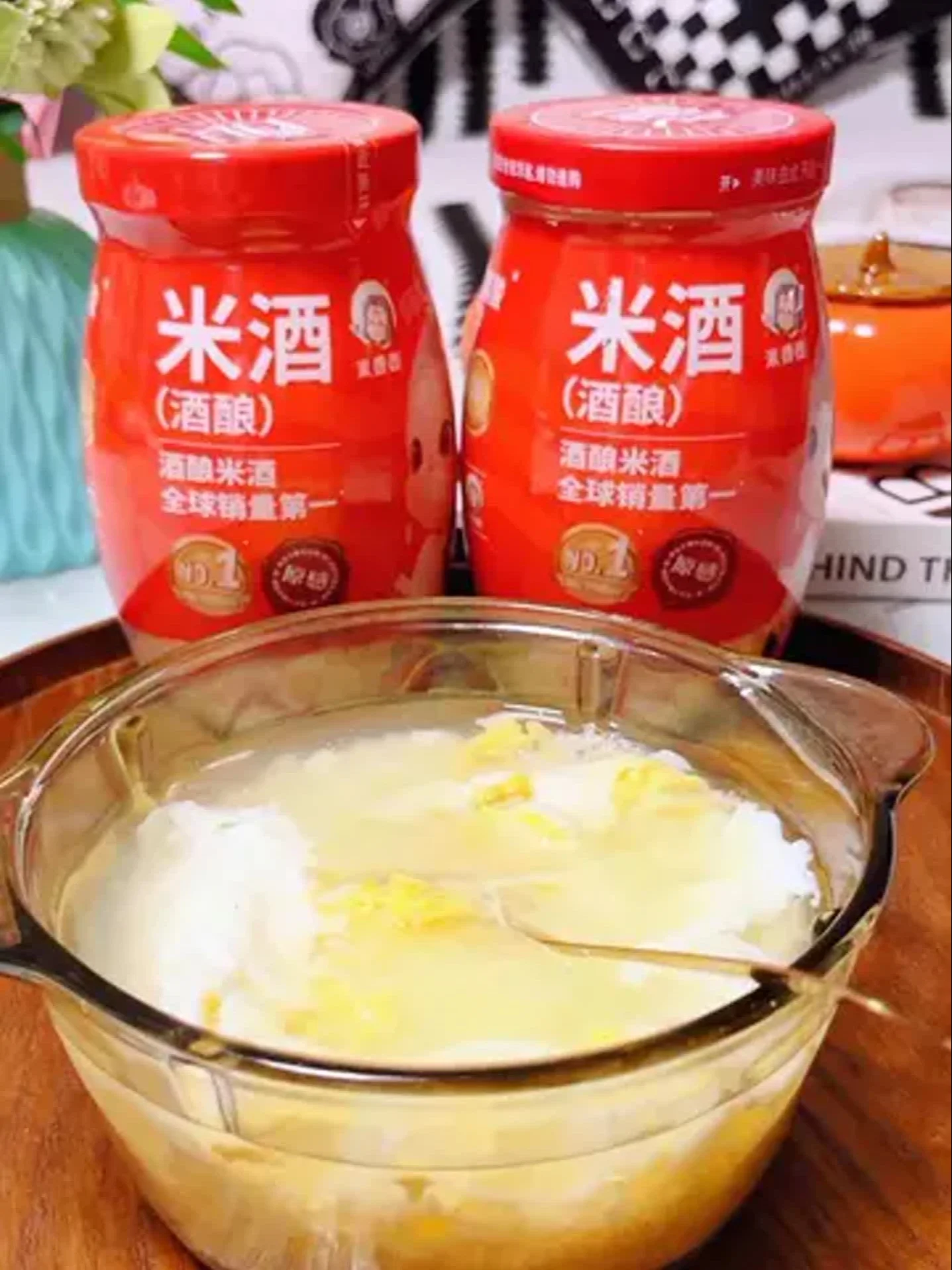 透明玻璃罐中正在发酵的米酒，米粒间充满气泡，旁边摆放着酿酒用的酒曲和温度计_1