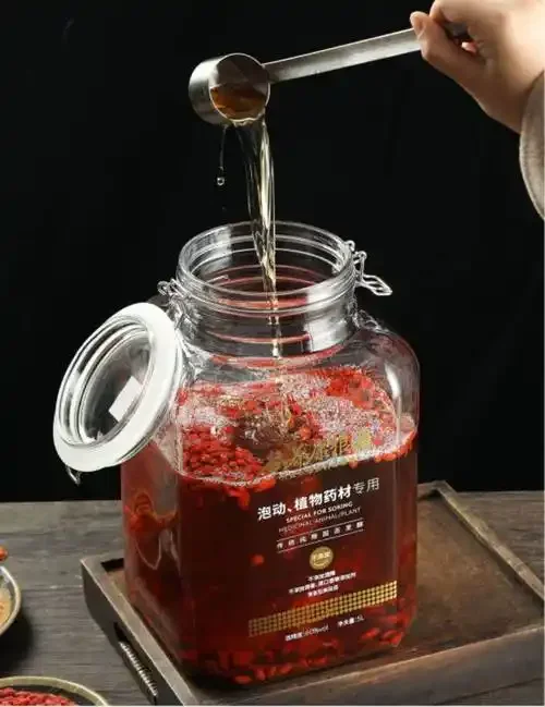 中医养生白酒浸泡过程特写：玻璃酒坛内人参、枸杞等药材在琥珀色酒液中清晰可见_1