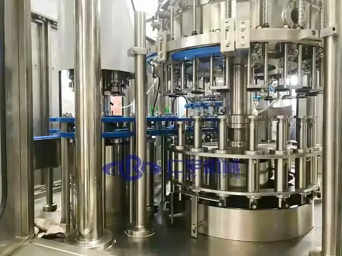 南楼山酿酒师在小型酒坊中操作一套不锈钢鲜啤酒酿造设备，旁边是刚酿好的金黄色鲜啤。_1