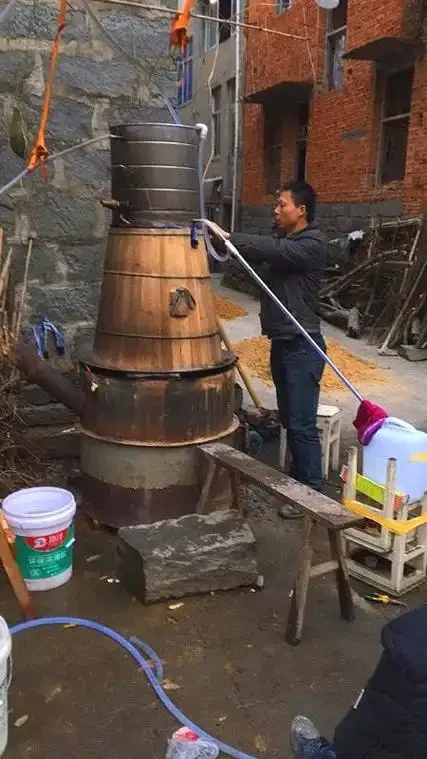 四川酿酒师傅正在操作现代不锈钢酿酒设备的实景工作照片_1