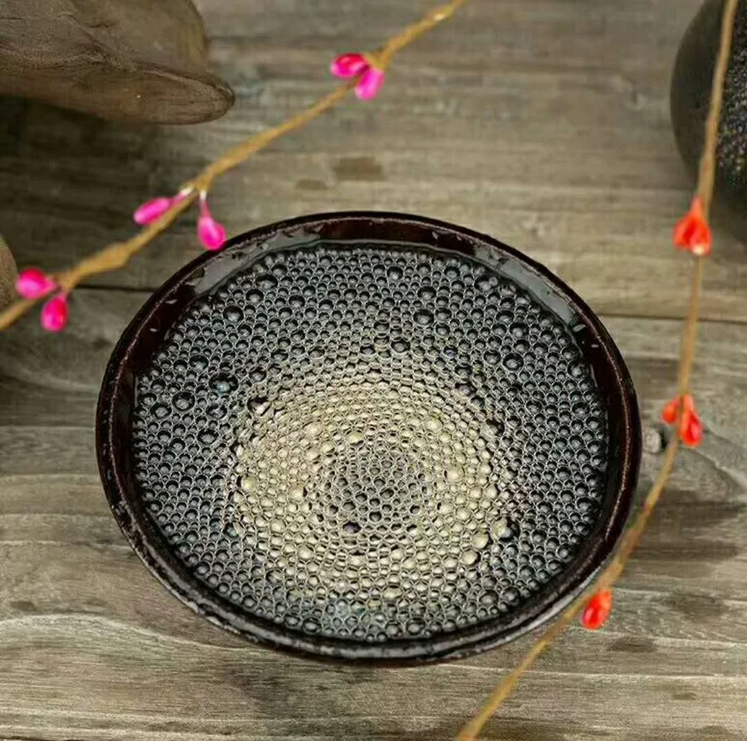 特写镜头下一碗粮食酒表面细密持久的白色酒花，背景为传统酿酒作坊环境_1