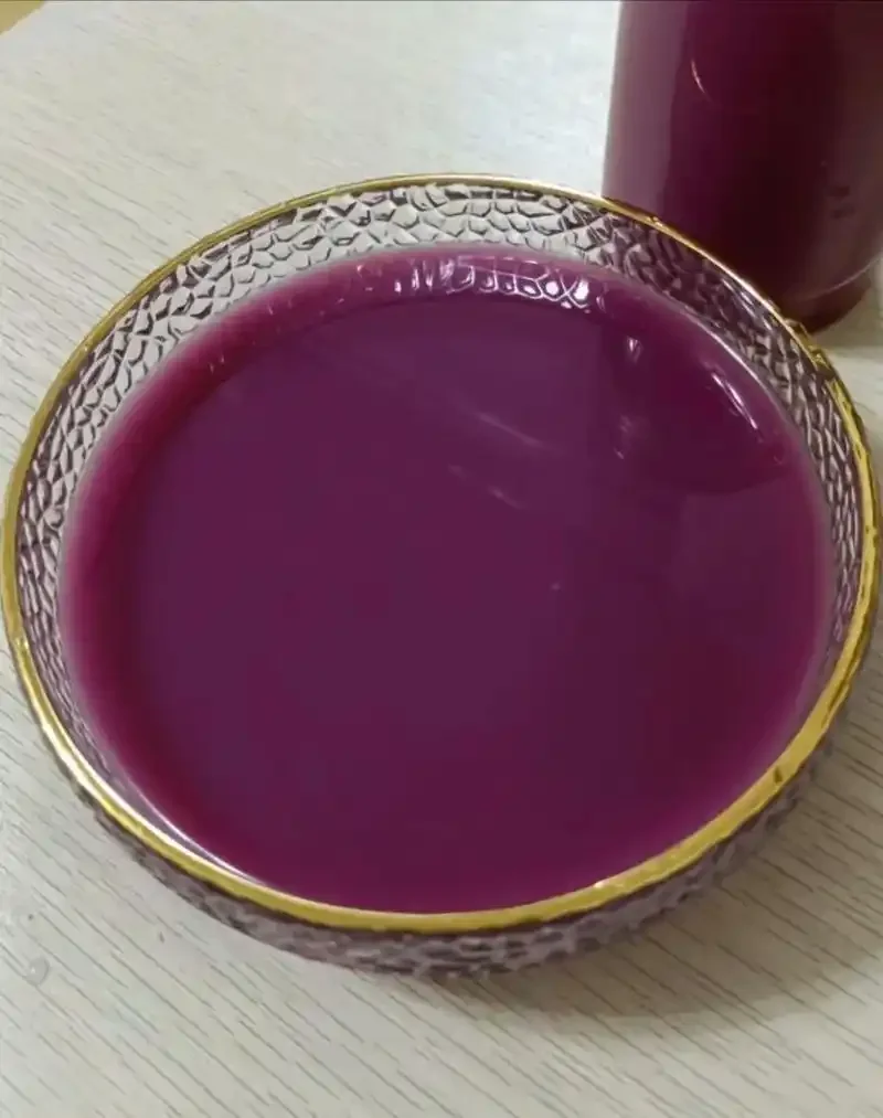 家庭自制蓝莓米酒发酵过程特写：玻璃罐中蓝莓与糯米混合，液体呈淡粉色，表面有气泡，展现自然发酵的活力。_1