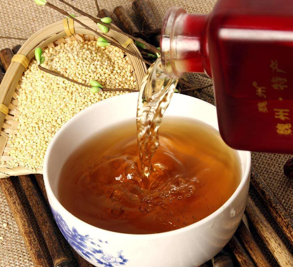 老酒师手工将优质糯米投入陶坛，准备黄酒发酵的场景特写_1