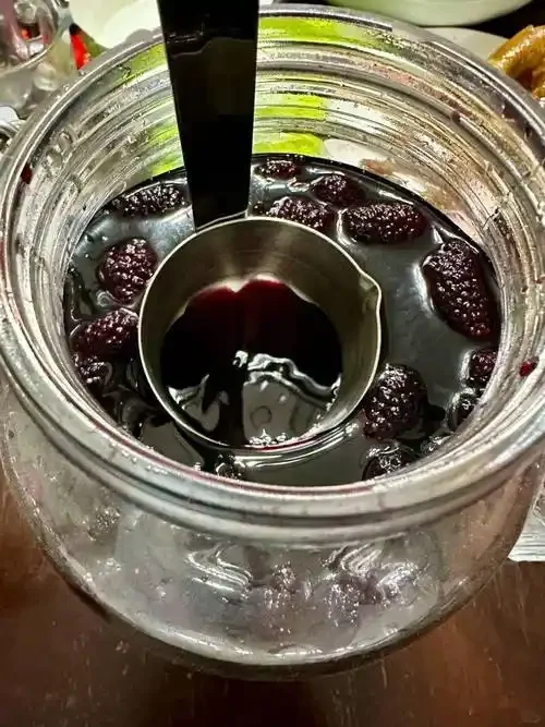 自制桑葚泡酒：透明玻璃罐中紫红色桑葚与白酒混合，旁边是新鲜桑葚和冰糖。_1