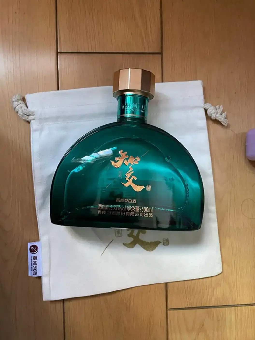百元价位纯粮白酒品鉴桌：多款光瓶酒与盛有酒液的玻璃杯，背景有谷物点缀，风格真实温暖。_1