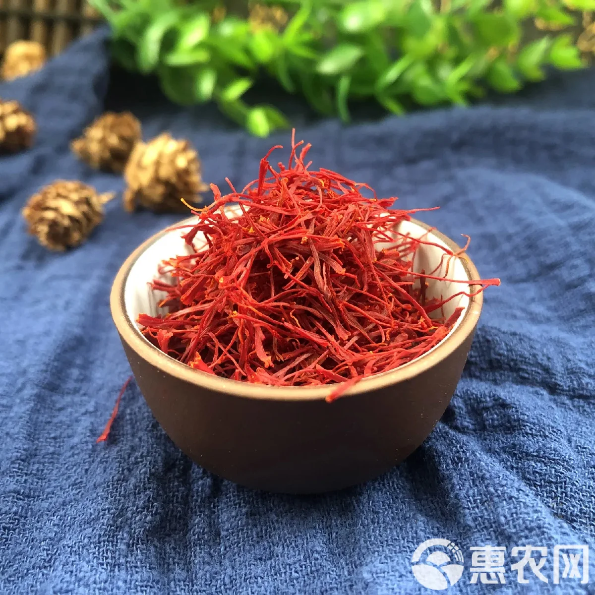 一瓶浸泡中的藏红花酒，酒液呈金黄色，瓶底可见藏红花，旁边散落着新鲜花丝与酒杯_1