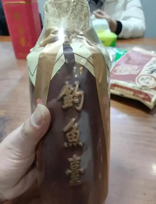 一瓶钓台公酒与一杯酒液的近距离实拍，展现其古朴包装与清澈色泽_1