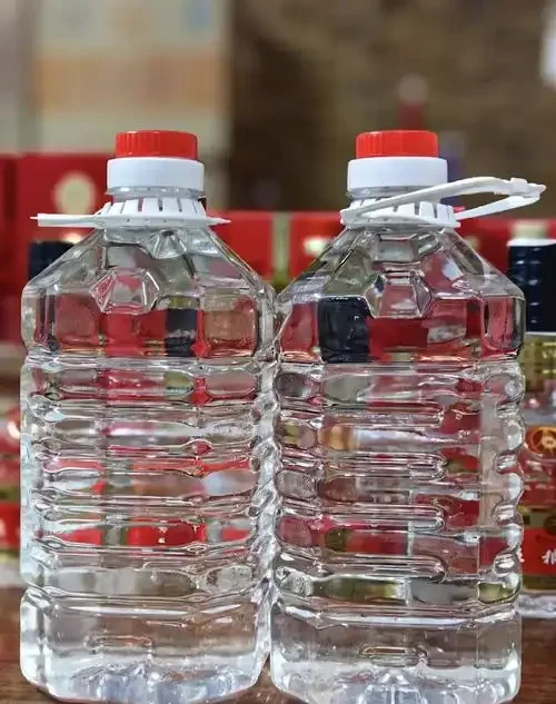 农家小院窗台上，盛装在透明玻璃坛中的琥珀色纯粮散酒特写，旁边散落着酿酒原料高粱和酒曲。_1