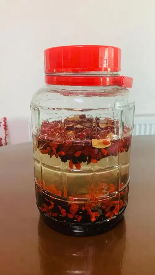 家庭自制黑豆泡酒特写：玻璃瓶中黑豆与琥珀色酒液清晰可见，旁边配有原料黑豆、小秤和手写配方卡。_1