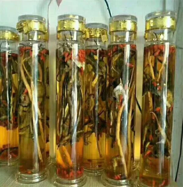 海马泡酒成品展示图：透明玻璃罐内装满海马、枸杞与金黄色酒液_1
