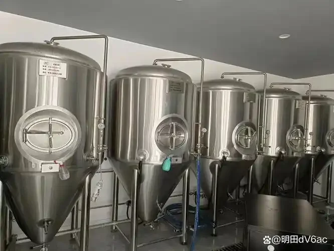 现代酒厂车间内，酿酒师正在操作大型不锈钢发酵与蒸馏设备_1
