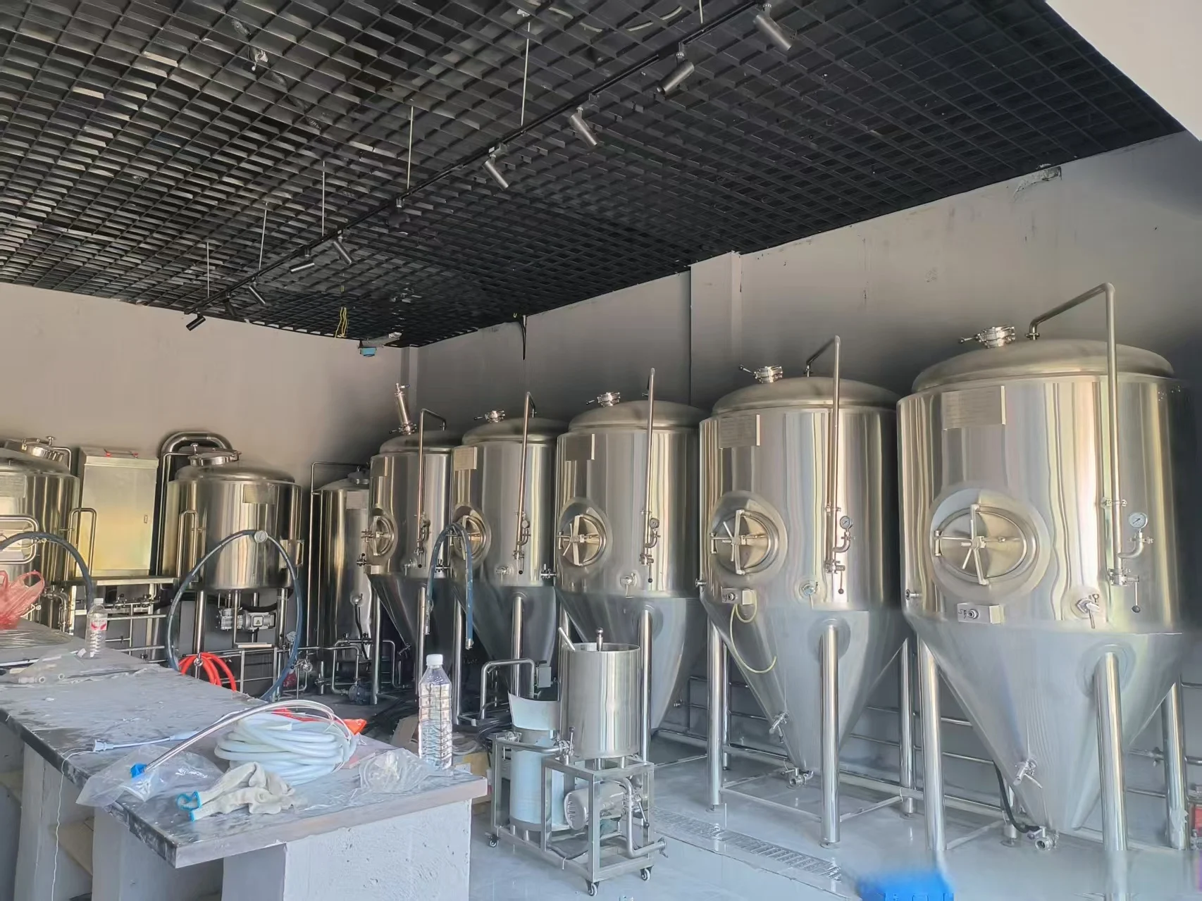 酿酒师在现代化啤酒厂操作不锈钢糖化煮沸设备和发酵罐_1