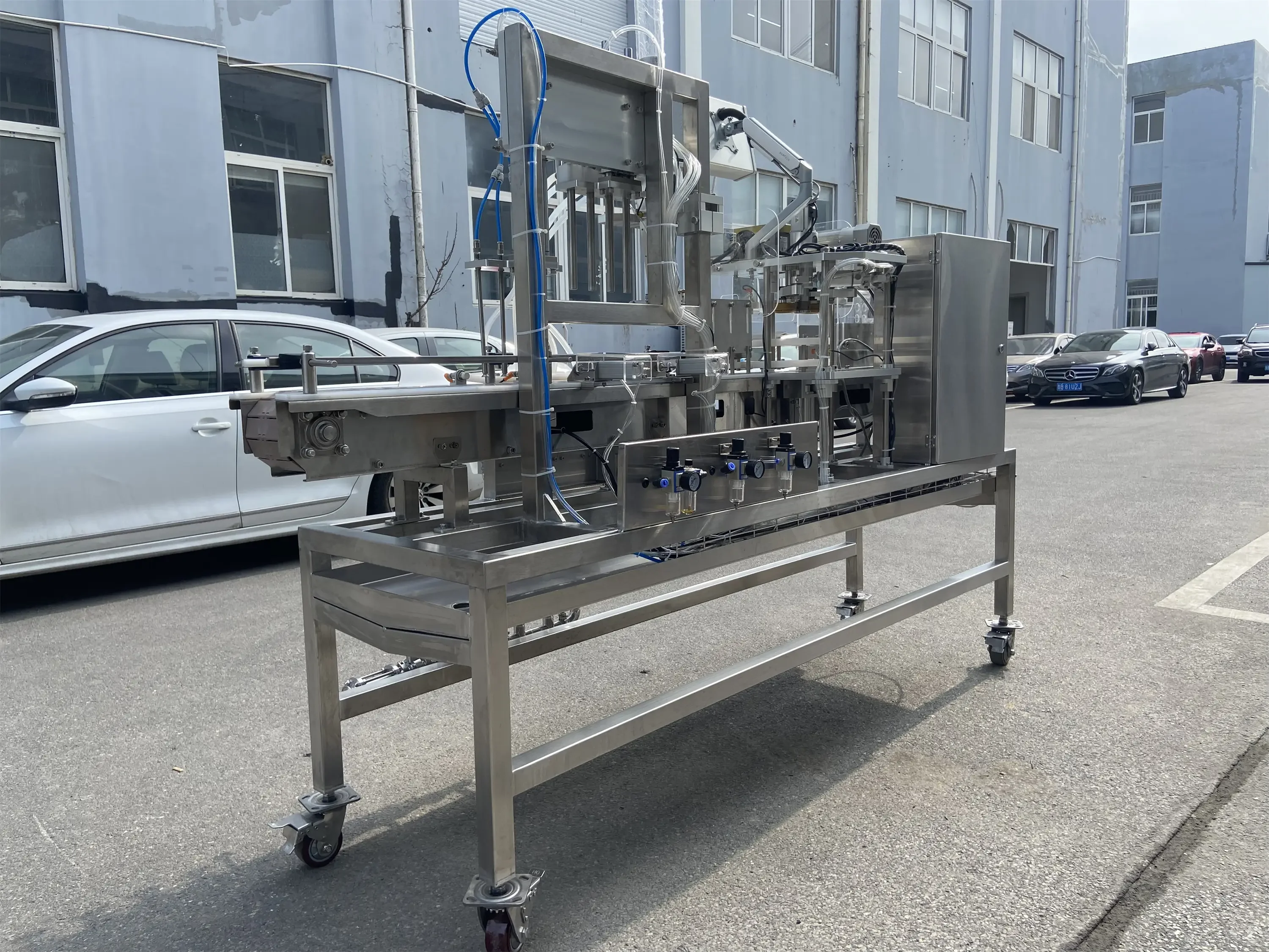 一套100升不锈钢精酿啤酒酿造设备在专业工作间内的展示，包含糖化煮沸锅和发酵罐，旁边配有酿酒原料。_1