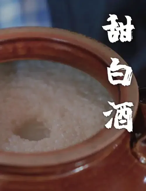 一碗热气腾腾、点缀着枸杞红枣的家酿甜米酒（甜白酒），旁边放着酿酒笔记本和糯米，氛围温馨。_1