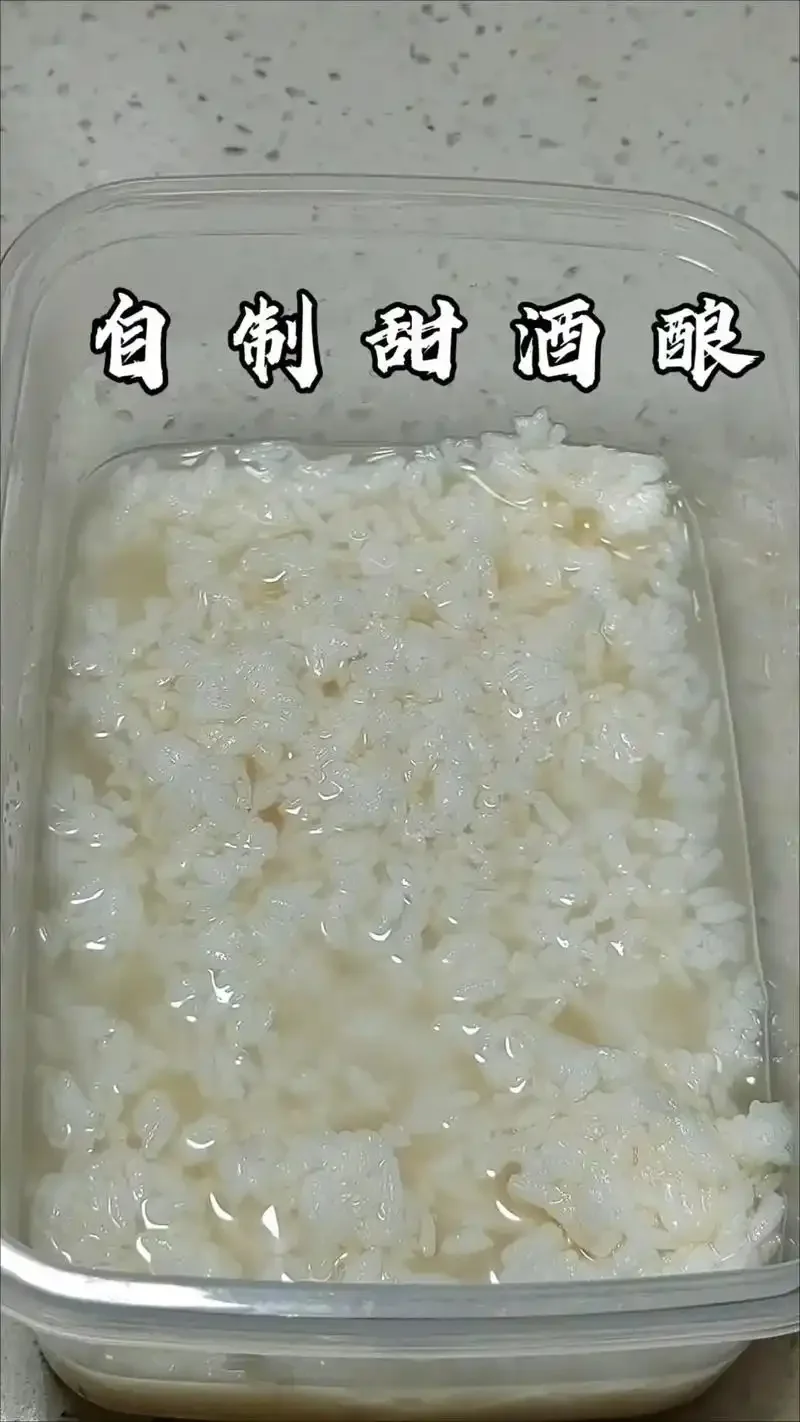 家用玻璃罐中成功发酵的甜酒醪糟，米粒晶莹，酒汁清亮，展示家庭酿造的成果。_1