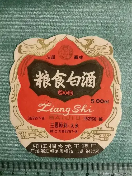 特写白酒瓶身标签，配料表和水、高粱、小麦等文字清晰可见，旁边散落着真实酿酒粮食，用于解释纯粮食酒的标志。_1