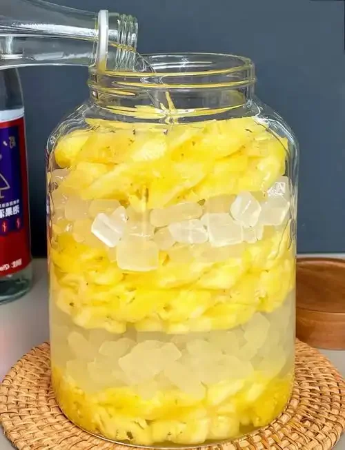 家庭自制菠萝蜜泡酒：玻璃罐中金黄菠萝蜜果肉浸泡在清澈酒液中，旁边散落新鲜果肉，展现手工酿造过程。_1