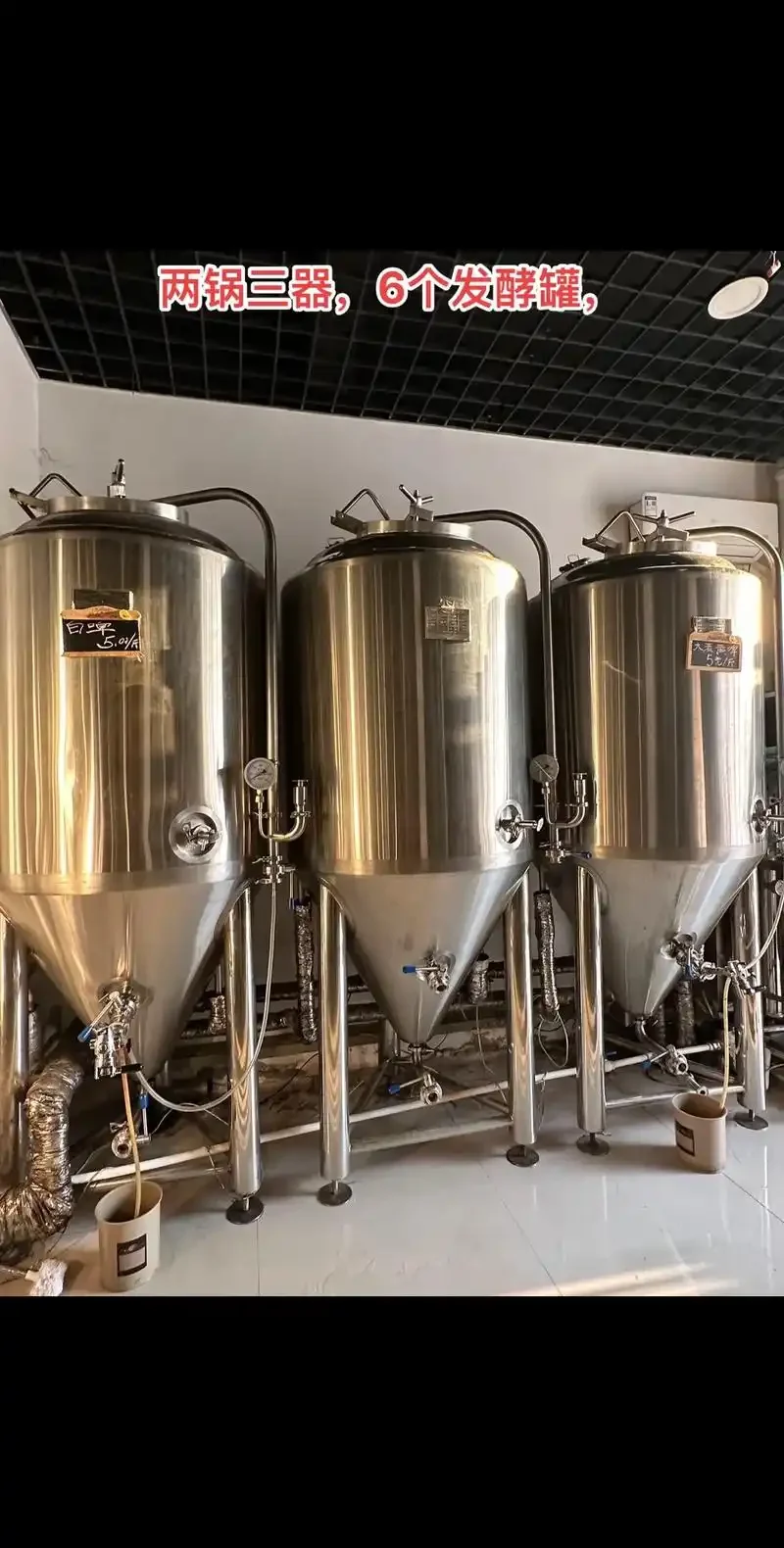 一套摆放在家庭工作台上的不锈钢家酿啤酒设备，包含糖化桶、煮沸锅和发酵罐。_1