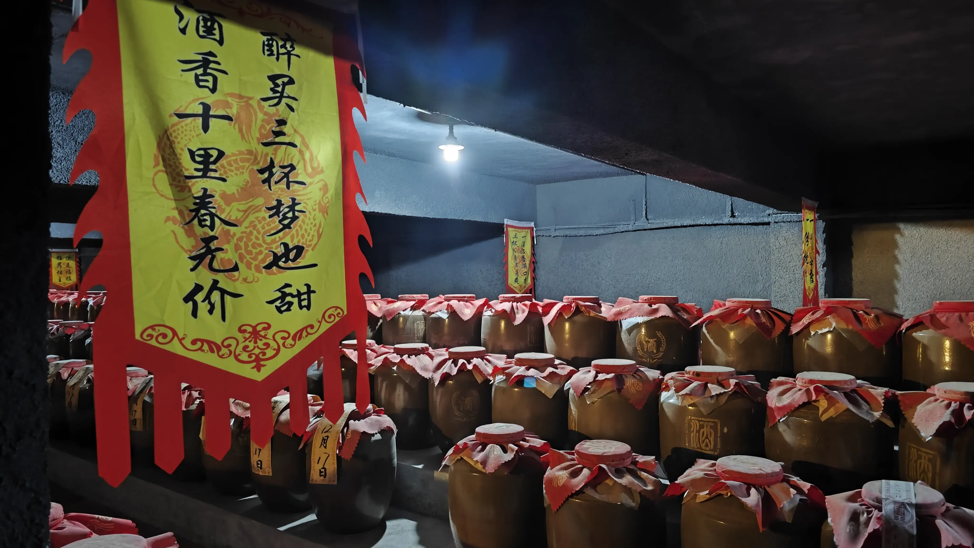 酿酒师的手正在清理半埋于老窖泥中的传统土陶酒坛，展现泥土窖藏的质朴与岁月感_1