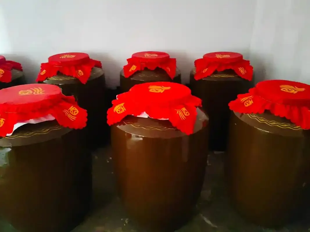 对比展示：左侧玻璃杯中纯高粱酒酒花细密，右侧空杯挂杯明显，背景有红高粱穗，用于鉴别纯粮酒_1